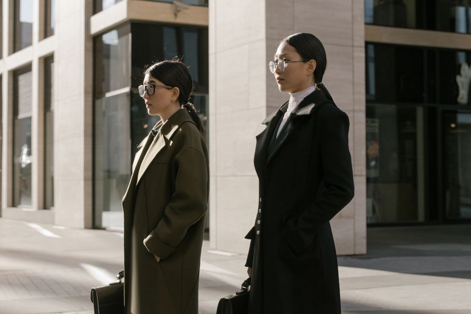 Two professionals reviewing a planning notebook outside their office