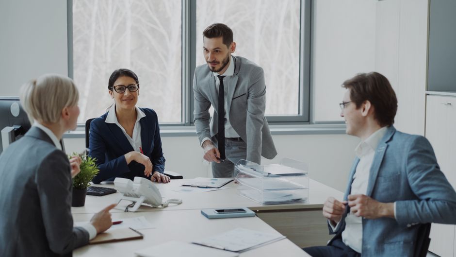 Group of professionals in a modern office setting discussing business strategies.