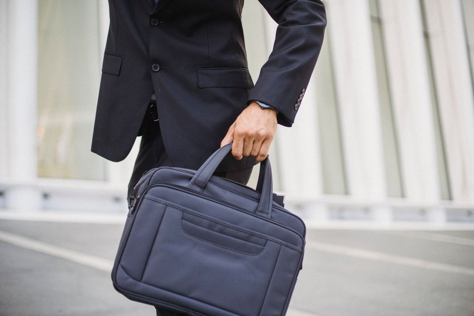 Close-up of a businessman carrying a briefcase in urban environment.