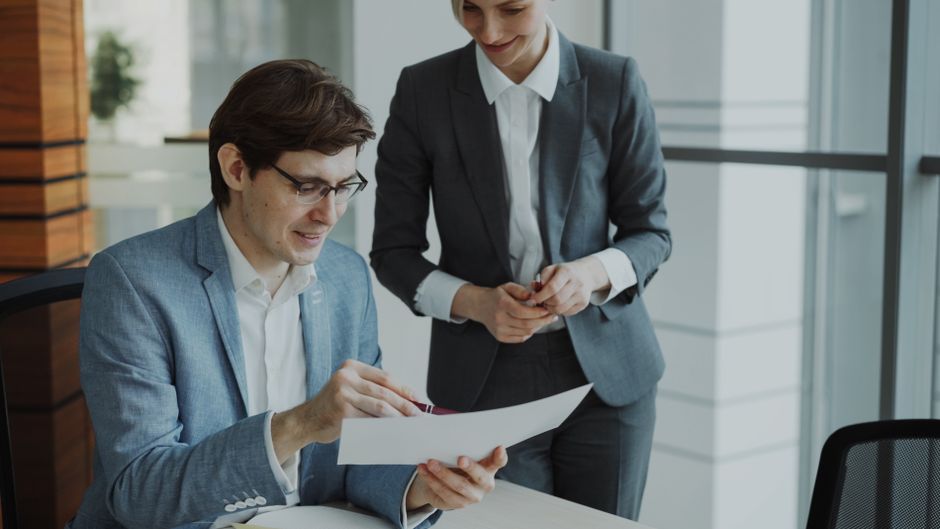 Two professionals reviewing a wedding stationery bundle proposal